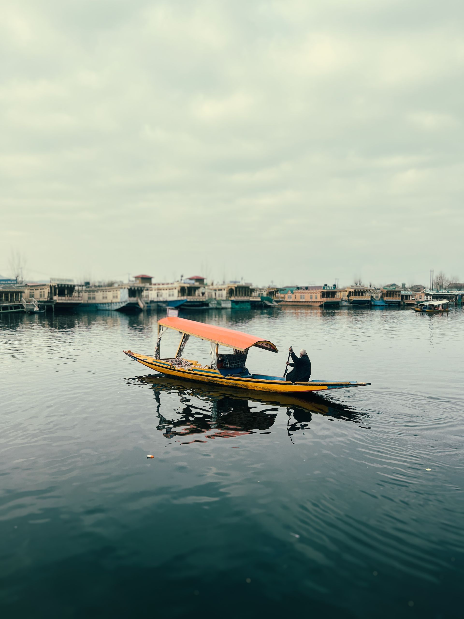 A shikara with an orange canopy on Dal Lake in Srinagar.